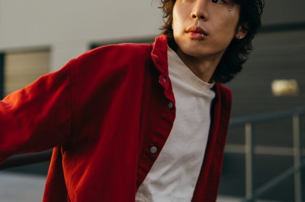 a young man in a red jacket is posing for a picture